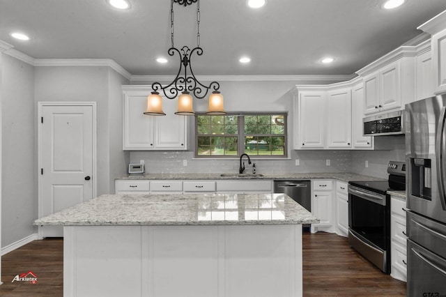 kitchen with white cabinets, pendant lighting, appliances with stainless steel finishes, and a center island