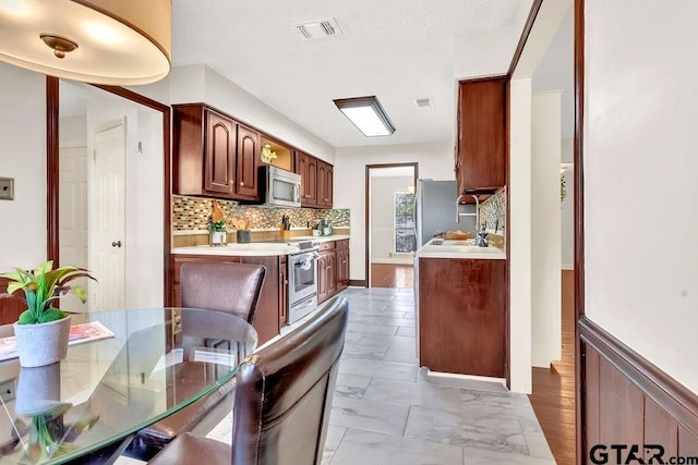 kitchen featuring decorative backsplash and appliances with stainless steel finishes