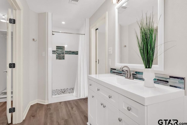 bathroom featuring a shower with curtain, vanity, hardwood / wood-style flooring, and tasteful backsplash