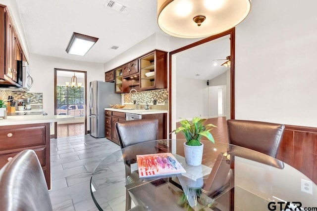 dining area featuring sink, lofted ceiling, and an inviting chandelier