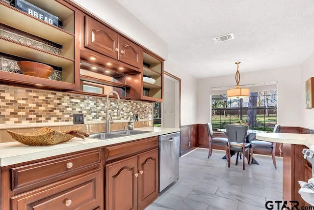 kitchen featuring dishwasher, sink, pendant lighting, a textured ceiling, and decorative backsplash