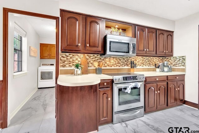 kitchen with washer / dryer, stainless steel appliances, and tasteful backsplash