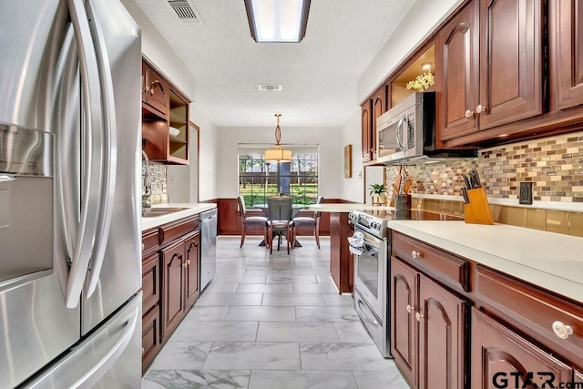 kitchen with pendant lighting, decorative backsplash, and stainless steel appliances