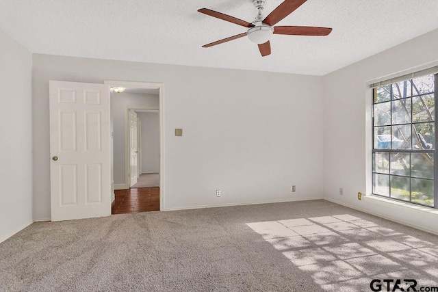 carpeted spare room with ceiling fan and a textured ceiling