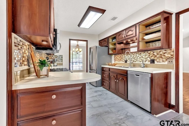 kitchen with backsplash, dishwasher, sink, and a notable chandelier