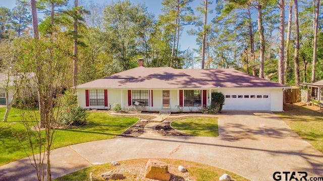 ranch-style house featuring a front yard, a porch, and a garage