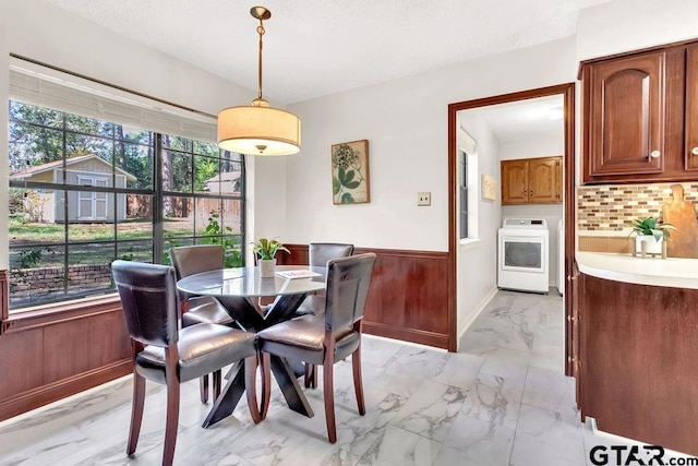 dining area featuring washer / clothes dryer and wooden walls