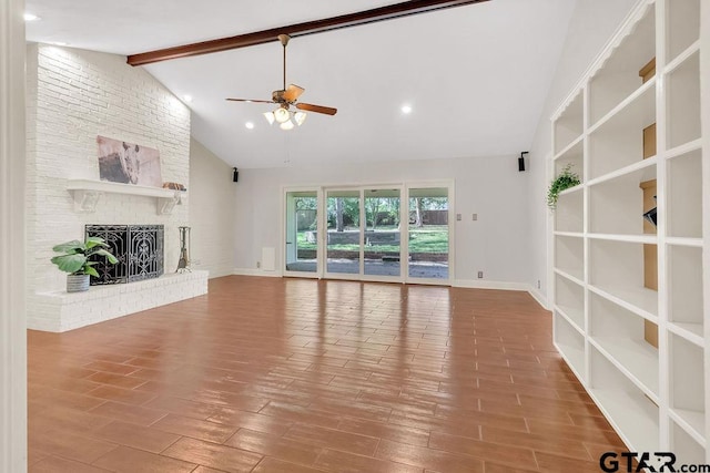 unfurnished living room with beam ceiling, ceiling fan, high vaulted ceiling, wood-type flooring, and a fireplace