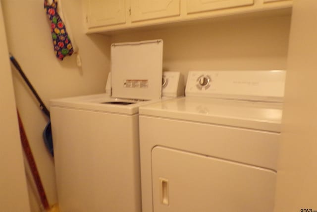 laundry room with cabinets and washer and clothes dryer