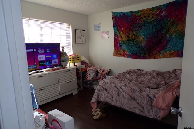 bedroom featuring a textured ceiling and dark wood-type flooring