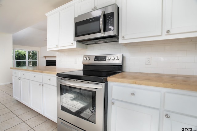 16530 Echo Glen Dr, Tyler, TX 75703 - kitchen with stainless steel appliances, butcher block countertops, light tile patterned floors, and decorative backsplash