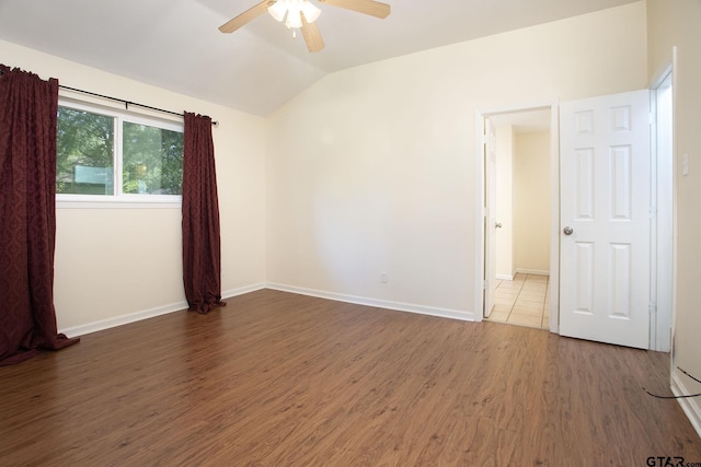 16530 Echo Glen Dr, Tyler, TX 75703 - spare room featuring a ceiling fan, vaulted ceiling, wood finished floors, and baseboards