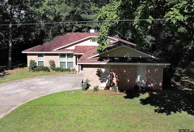 16530 Echo Glen Dr, Tyler, TX 75703 - view of front of property with concrete driveway, brick siding, and a front yard
