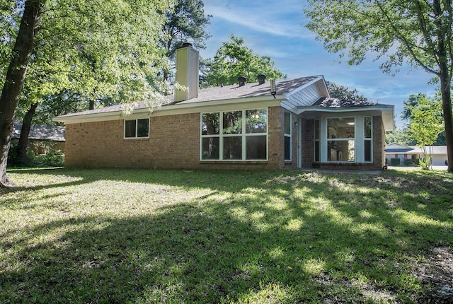 16530 Echo Glen Dr, Tyler, TX 75703 - back of property featuring a lawn, a chimney, and brick siding