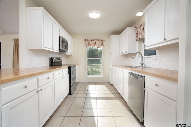 16530 Echo Glen Dr, Tyler, TX 75703 - kitchen featuring stainless steel appliances, wood counters, a sink, and tasteful backsplash