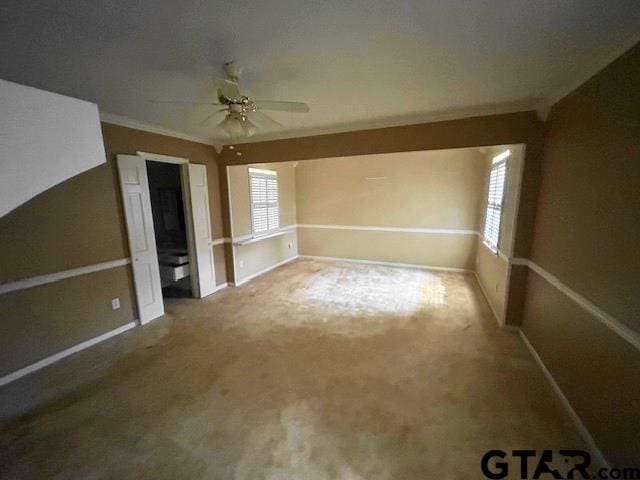 interior space featuring carpet, ceiling fan, and crown molding