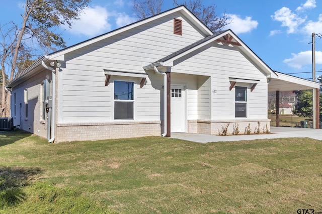 view of front facade featuring central air condition unit, a front lawn, and a carport