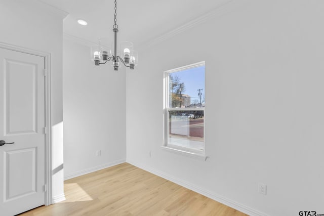 unfurnished dining area featuring an inviting chandelier, light hardwood / wood-style flooring, and ornamental molding