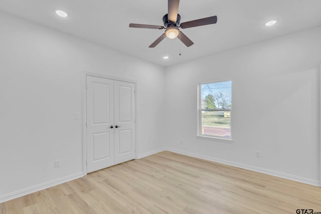 spare room featuring light hardwood / wood-style flooring and ceiling fan