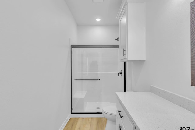 bathroom featuring hardwood / wood-style floors, vanity, toilet, and walk in shower