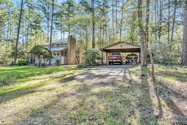 view of front of home featuring a detached carport, driveway, and a front lawn