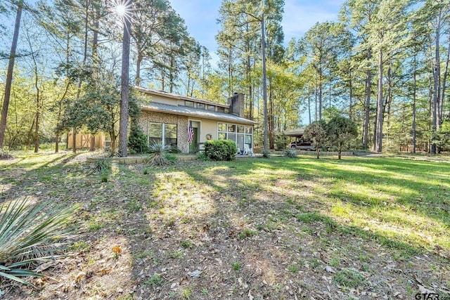 exterior space featuring a chimney and a front yard