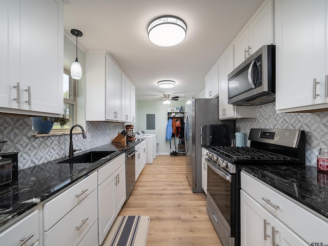 kitchen featuring white cabinetry, a sink, stainless steel appliances, and light wood-style floors