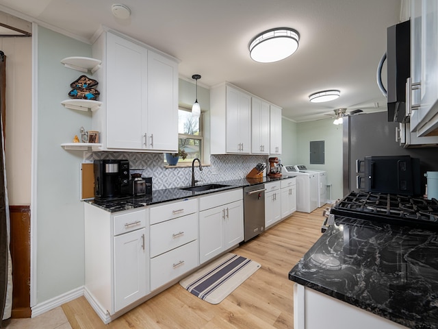 kitchen with white cabinetry, a sink, backsplash, and separate washer and dryer