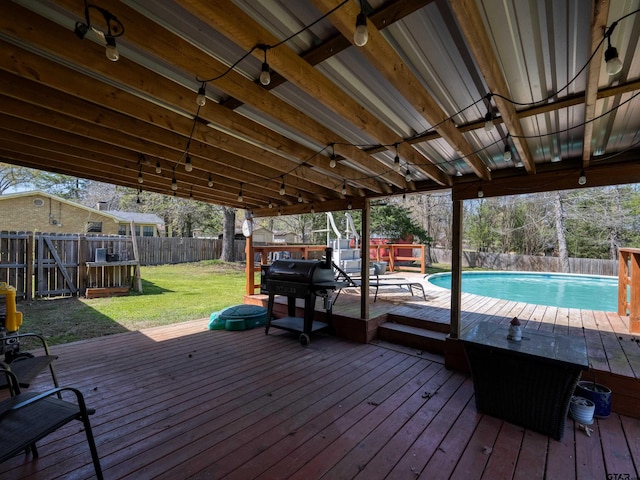 deck with a fenced backyard, a fenced in pool, and a lawn