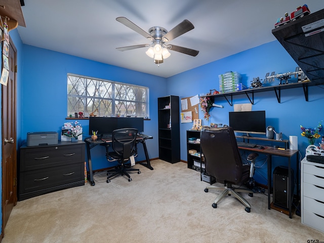 carpeted office featuring baseboards and a ceiling fan