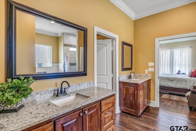 bathroom featuring crown molding, wood finished floors, and a sink