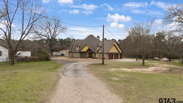 view of front of home with a front yard, a garage, and driveway