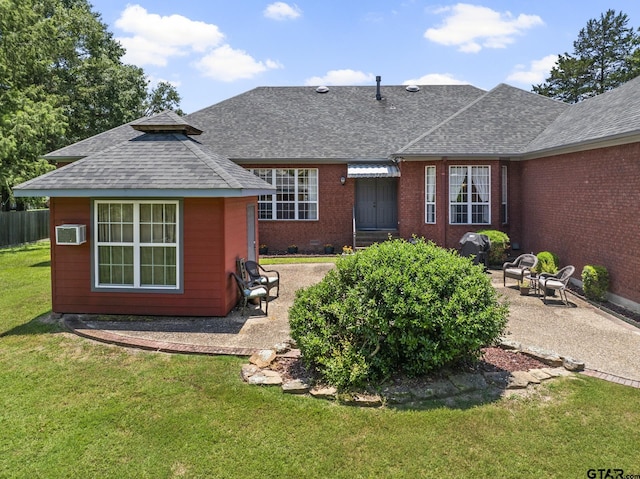 back of property featuring a wall mounted air conditioner, a patio area, and a lawn