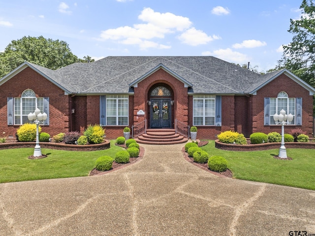 view of front of property featuring french doors and a front lawn