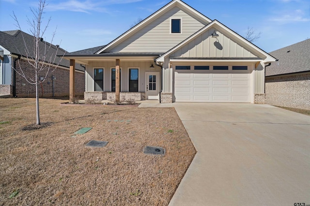 view of front of house featuring driveway, covered porch, board and batten siding, and brick siding