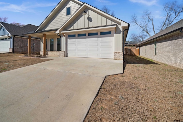 view of front of property with a garage, concrete driveway, brick siding, and board and batten siding