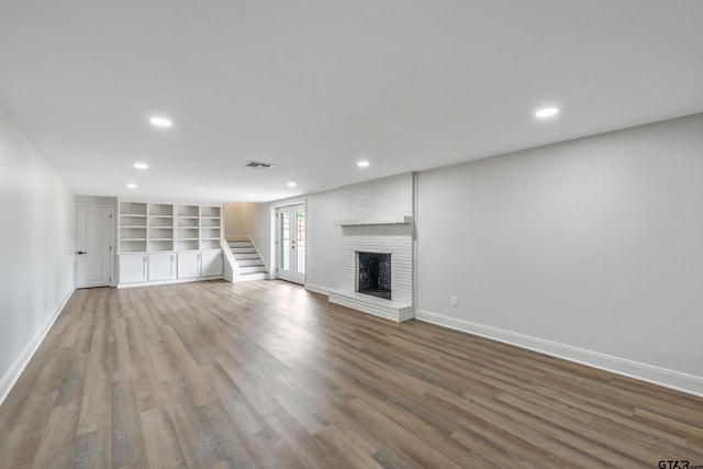 2918 Oak Knob Dr, Tyler, TX 75701 - unfurnished living room featuring baseboards, wood finished floors, recessed lighting, a fireplace, and stairs