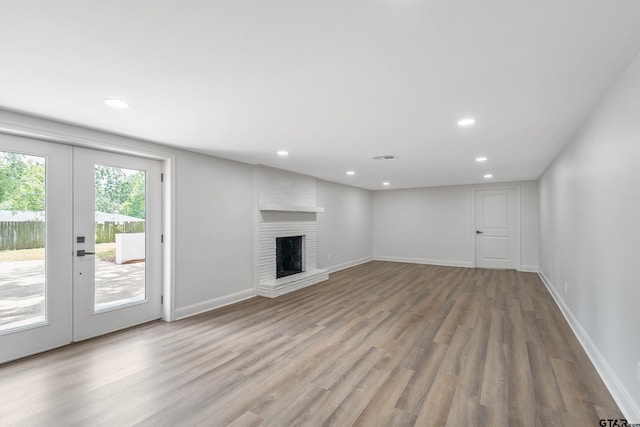 2918 Oak Knob Dr, Tyler, TX 75701 - unfurnished living room featuring wood finished floors, baseboards, recessed lighting, a fireplace, and french doors