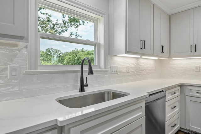 2918 Oak Knob Dr, Tyler, TX 75701 - kitchen with stainless steel dishwasher, a sink, tasteful backsplash, and white cabinetry