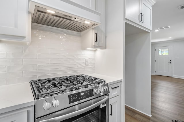 2918 Oak Knob Dr, Tyler, TX 75701 - kitchen with custom range hood, stainless steel range with gas stovetop, baseboards, white cabinets, and wood finished floors