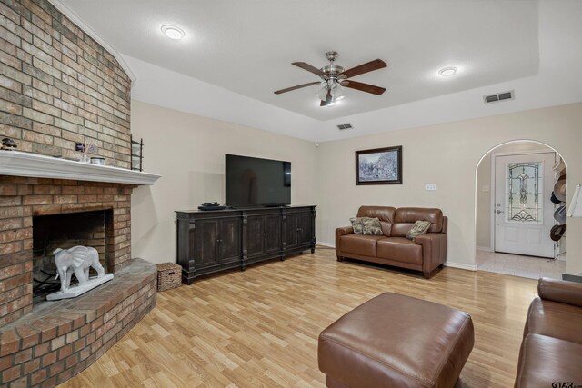 1039 Fm 2909, Canton, TX 75103 - living area with light wood-style floors, a ceiling fan, arched walkways, a brick fireplace, and baseboards