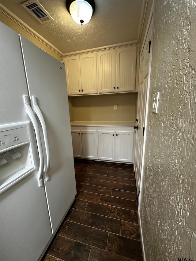 interior space with visible vents, cabinet space, a textured ceiling, and wood tiled floor