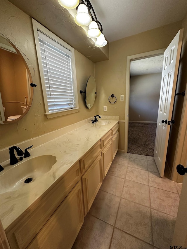 full bath with tile patterned floors, double vanity, and a sink