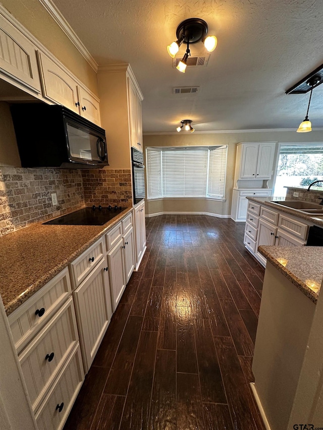 kitchen featuring black appliances, a sink, stone countertops, a textured ceiling, and dark wood-style floors