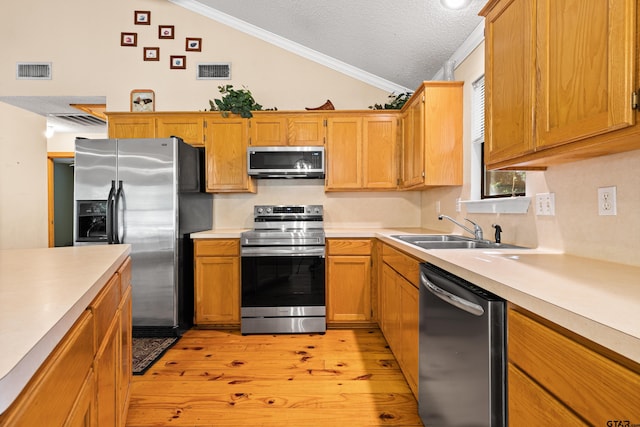 149 Primrose Path, Hawkins, TX 75765 - kitchen with stainless steel appliances, a sink, vaulted ceiling, light wood-style floors, and light countertops