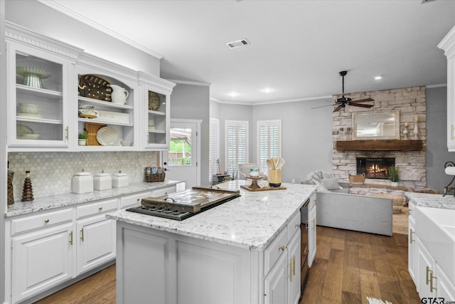 1807 Mill Creek Rd, Canton, TX 75103 - kitchen with black cooktop, ornamental molding, a center island, a fireplace, and a ceiling fan