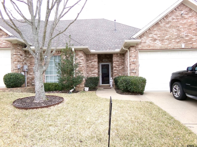 single story home with a garage, brick siding, a shingled roof, and a front lawn