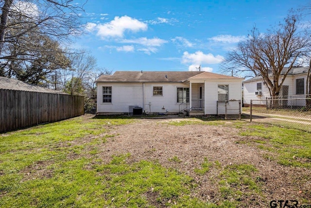 rear view of property featuring a lawn and a fenced backyard