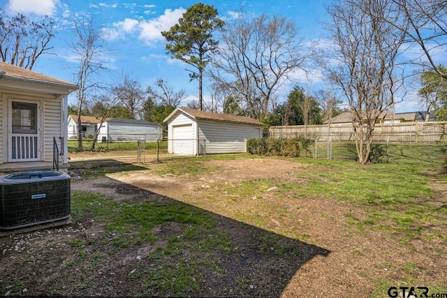 view of yard with a garage, fence, cooling unit, and an outdoor structure