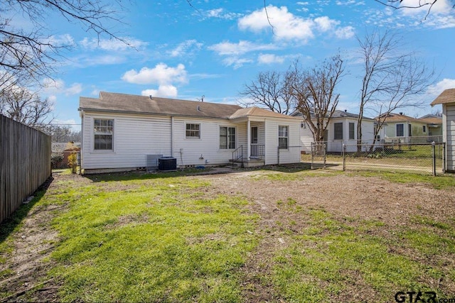 rear view of property with a fenced backyard and a lawn